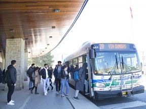 Riders get on and off  an LTC bus at Western University's Alumni Hall in London. (Derek Ruttan/The London Free Press)