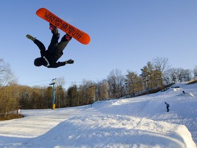 Owen Apthorp, 16, of London launches into a backflip on his snowboard, which bears the logo "Wasted Youth," at Boler Mountain in London, Ont. The club is on its very last week of the season and a group of young skiers and snowboarders were making the most of the perfect spring skiing weather. Photograph taken on Tuesday March 26, 2019.  Mike Hensen/The London Free Press/Postmedia Network