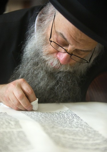 Rabbi Samuel Zirkind checks whether the ink had dryed as he completes a Torah scroll, inking each letter in the holy Jewish text, at Alumni Hall at Western on Sunday, March 31, 2019. The scroll was dedicated to Yitzchok Block and his wife Laya, prominent members of the Jewish community in London who founded Chabad House at Western and the London Community Hebrew Day School.  Mike Hensen/The London Free Press/Postmedia Network