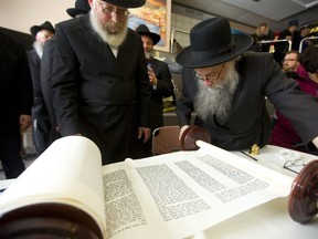 Rabbi Samuel Zirkind starts to roll up the Torah scroll, after inking the final letters in the holy Jewish text at Alumni Hall Sunday, March 31, 2019. The scroll was dedicated to Yitzchok Block and his wife Laya, prominent members of the Jewish community in London who founded Chabad House at Western University and the London Community Hebrew day school.  Mike Hensen/The London Free Press