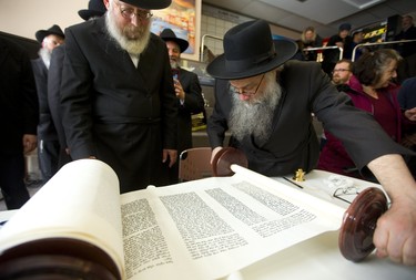 Rabbi Samuel Zirkind starts to roll up the Torah scroll, after inking the final letters in the holy Jewish text at Alumni Hall Sunday, March 31, 2019. The scroll was dedicated to Yitzchok Block and his wife Laya, prominent members of the Jewish community in London who founded Chabad House at Western University and the London Community Hebrew day school.  Mike Hensen/The London Free Press