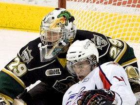 Windsor Spitfire Tom Kuhnhackl crashes into London Knights  goaltender Michael Houser in the third period of their game at the John Labatt Centre in London, Ontario on Monday February 21, 2011. The Knights won the game, 3-2. Houser was named first star of the game. (DEREK RUTTAN/The London Free Press)