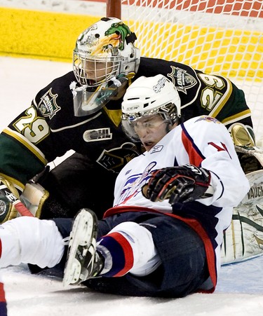 Windsor Spitfire Tom Kuhnhackl crashes into London Knights  goaltender Michael Houser in the third period of their game at  the John Labatt Centre in London, Ontario on Monday February 21, 2011. The Knights won the game, 3-2. Houser was named first star of the game.DEREK RUTTAN/THE LONDON FREE PRESS/QMI AGENCY