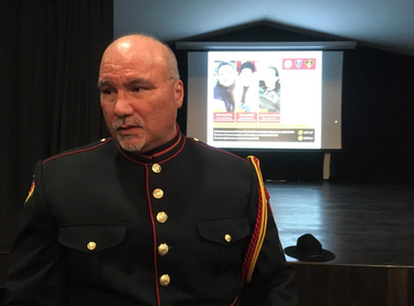 Darren Montour, acting deputy chief of the Six Nations police, speaks after a press conference updating the police probe into a triple homicide. Behind him are photos of the victims, whose bodies were found in November west of London, near Oneida Nation of the Thames.