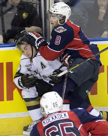 London Knight Brett Welychka is checked into the boards by Windsor Spitfire Trevor Murphy during OHL action in London, Ont. on Friday December 6, 2013.DEREK RUTTAN/ The London Free Press /QMI AGENCY