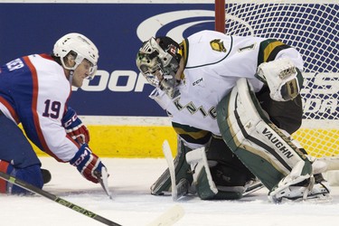 London Knights goaltender Tyler Parsons covers his post as Windsor Spitfires forward Christian Fischer looks to play the puck from his knees during their OHL hockey game at Budweiser Gardens in London, Ont. on Friday December 4, 2015. Craig Glover/The London Free Press/Postmedia Network