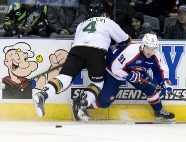 Windsor Spitfires forward Aaron Luchuk dodges a hit by London Knights defenceman Olli Juolevi during their OHL hockey game at Budweiser Gardens in London, Ont. on Friday December 4, 2015. Craig Glover/The London Free Press/Postmedia Network