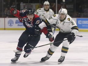 Luke Boka, left, of the Windsor Spitfires gets tied up by Evan Bouchard of the London Knights during game 3 of their playoff series at the WFCU Centre in Windsor, ON.  (DAN JANISSE/The Windsor Star)