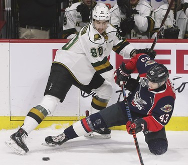 Alex Formenton, left, of the London Knights and Louka Henault of the Windsor Spitfires battle for the puck during game 4 of their playoff series on Thursday, March 28, 2019 at the WFCU Centre in Windsor, ON. (DAN JANISSE/The Windsor Star)