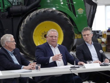 Ontario Premier Doug Ford, centre, Minister of Agriculture, Food and Rural Affairs Ernie Hardeman, left, and Minister of Environment, Conservation and Parks Rod Phillips talk before a roundtable with local farmers at Veldale Farms Ltd. south of Woodstock, Ont. on Thursday March 21, 2019. (Greg Colgan/Woodstock Sentinel-Review)
