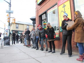 People pass boxes of books along a human chain Monday morning between the old Brown and Dickson Book Shop location on Richmond Street to its new location one block south.  Volunteers helped the store owners move about 200 boxes or books a some furniture. (JONATHAN JUHA, The London Free Press)