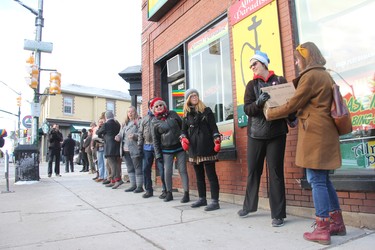 Close to 50 people gathered in downtown London Monday morning, forming a human chain to help the owners of Brown & Dickson Book Shop move close to 200 boxes with books to their new home. (JONATHAN JUHA, The London Free Press)