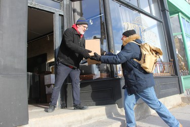 Brown & Dickson Book Shop owner Jason Dickson receives a box at the store’s new location from Dan Ebbs, who on Monday morning was helping out Dickson moving to the new space. (JONATHAN JUHA, The London Free Press)