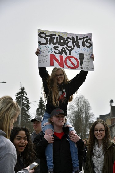 Jasmine Beadman, on the shoulders of Lucas Bergman, both Grade 11students at Huron Park, took part in the protest near Oxford MPP Ernie Hardeman's Woodstock office Thursday. Students from Woodstock's high schools walked out of classes in the afternoon as part of a provincewide protest against education cuts by the Ontario government. KATHLEEN SAYLORS/SENTINEL-REVIEW