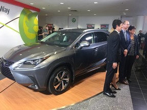Officials pose for pictures with the Lexus NX which will start rolling off the line at Toyota's Cambridge plant in 2020.  (NORMAN DE BONO, The London Free Press)
