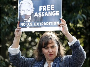 Spanish MEP Ana Miranda holds up a placard in support of WikiLeaks founder Julian Assange as she and German members of the Left Group in the Bundestag Heike Hansel and Sevim Dagdelen hold a press conference outside Belmarsh Prison where Assange is currently being held in London, Monday, April 15, 2019.