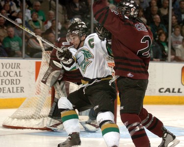 London Knights Dylan Hunter tangles with Michael Caruso of the Guelph Storm in front of the Storm net during the first period.