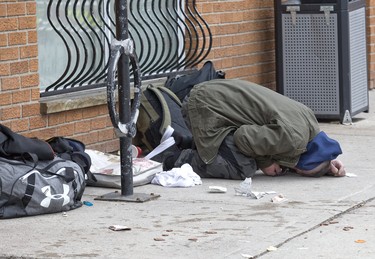 An incapacitated man lies crumpled on the sidewalk in front of the Salvations Army's Centre of Hope in London, Ont. on Friday April 5, 2019. He and a woman ingested what police said was likely fentanyl, leading to the woman overdosing. The woman was revived with naloxone, an overdose antidote, administered by fellow clients of the facility. After being examined by paramedics the woman refused to go to hospital and was released at the scene. The man eventually rose to his feet with help from Centre of Hope staff. Derek Ruttan/The London Free Press/Postmedia Network