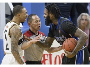 A referee gets between Xavier Moon, left, of the London Lightning and Akeem Ellis of the Kitchener Waterloo Titans as the two exchange unpleasantries during their NBL playoff game in London Tuesday April 9, 2019. Derek Ruttan/The London Free Press