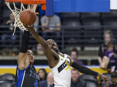 Kirk Williams Jr. of the London Lightning lays up a shot a while covered by Justin Strings of the Kitchener Waterloo Titans during their NBL playoff game in London Tuesday April 9, 2019.  (Derek Ruttan/The London Free Press)