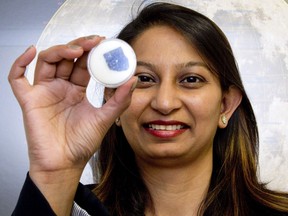 Parshati Patel holds a lunar meteorite at Western University in London on Thursday. She is the outreach co-ordinator with the school's Centre for Planetary Science and Exploration. The meteorite was discovered in Libya in 1998. (Derek Ruttan/The London Free Press)