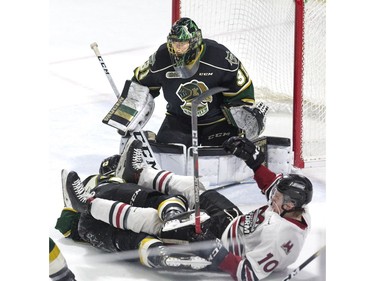 London Knights goalie Jordan Kooy watches the play over the tangled mess that is teammate Paul Cotter and MacKenzie Entwistle of the Guelph Storm during the second period of game seven in their playoff series on Tuesday April 16, 2019. Derek Ruttan/The London Free Press