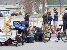 Paramedics and firefighters revive a female overdose victim in a parking lot at the northeast corner of Adelaide Street and Queens Avenue in London on Sunday. A man who found her said he ran to get help from a friend who had a naloxone kit. The two administered the overdose antidote to the woman while a third man  performed CPR until emergency personnel arrived. The woman was revived and taken to hospital in an ambulance. (Derek Ruttan/The London Free Press)