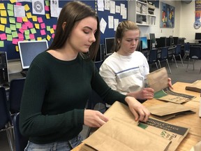 London Christian secondary school Grade 11 students Mia VanderHeide, left, and Sarah Hamstra fold bags for the London Food Bank spring food drive. The pair were among 224 students at the east London private school who folded 60,000 bags last week for the annual drive. The spring campaign, which runs until Sunday, is behind last year's take. (Jennifer Bieman/The London Free Press)