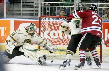 Matt Ashman keeps Zach Michell of the Guelph Storm from getting to a puck that had trickled through London goalie Michael Hutchinson until Hutchinson was able to fall on the puck and stop the play.The London Knights hosted the Guelph Storm Friday night at the John Labatt Centre. Justin Taylor's short handed goal set off their annual Teddy Bear toss that stopped the first period while the bears were cleaned off the ice.