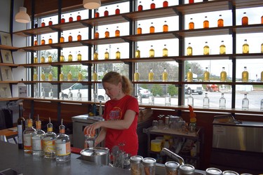 Bottles filled with spirits line the window as drinks are poured at Nashville Craft Distillery. (WAYNE NEWTON photo)