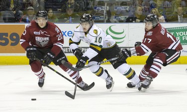 London Knights forward Christian Dvorak splits Guelph Storm players Luke Cairns, left, and Tyler Bertuzzi, right, as he skates hard to the net during their OHL junior hockey game at Budweiser Gardens in London on Friday December 19, 2014. CRAIG GLOVER The London Free Press / QMI AGENCY