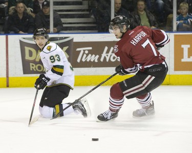 London Knights forward Mitch Marner smiles as he makes a pass from his knees while being chased by Guelph Storm defenseman Ben Harpur during their OHL junior hockey game at Budweiser Gardens in London on Friday December 19, 2014. CRAIG GLOVER The London Free Press / QMI AGENCY