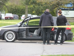 London police officers inspect a vehicle at the scene of a shooting at the corner of Trafalgar Street and Admiral Drive.