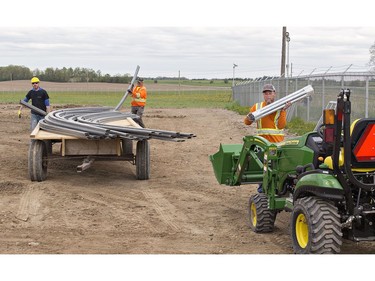 Workers prepare to erect three greenhouses for seedlings at 48North's Good Farm operation southeast of Brantford on Wednesday. With 100 acres surrounded by 8,300 feet of chain link and barbed wire fencing, 102 video cameras, infrared and vibration sensors, the farm will be one of the largest outdoor cannabis operations in Canada. The licensed producer received the green light from Health Canada on Friday to begin cultivation on its Brant County farm. (Brian Thompson/Postmedia Network)