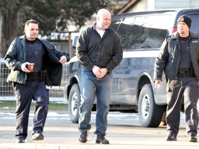 Mason Jenkins, wearing handcuffs and shackles, is flanked by two unidentified armed Correctional Service Canadaguards as he walks to a Chatham funeral home in 2013 for his paternal grandmother's funeral. Jenkins, who is serving a life sentence for the first-degree murder of his sister in 1998, was granted an escorted temporary absence to attend the interment of his father's ashes and celebration of his life at an undisclosed date.