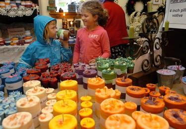 Emily Burtwistle, 6, left, of Lambeth, and her cousin, Alta Bennett, 8, of St. Marys, check out fragrant pure soy candles at the Cottage Curios and Garden shop operated by JoAnne and Ron Guille near Appin yesterday.  The girls were participating in the 39th annual London Free Press Shunpiker Mystery Tour. (London Free Press)