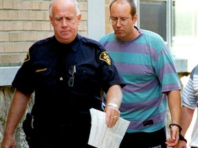 Thomas Dewald is seen in this file photo from August 1998 being escorted from Chatham court after a brief court appearance.