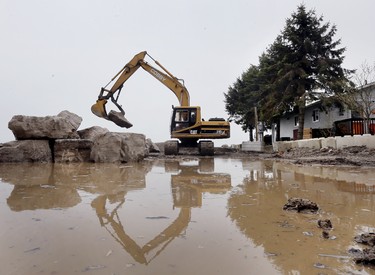 LEAMINGTON, ON. APRIL 30, 2019. --  A heavy equipment operator moves massive rocks to enforce a breakwall around a shoreline property on Cotterie Park Rd in Leamington, ON. on Tuesday, April 30, 2019. Recent rain and high winds prompted the Essex Region Conservation Authority to issue a flood warning in local areas. (DAN JANISSE/The Windsor Star)