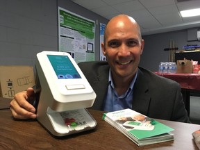 AceAge chief science officer with the company’s electronics pill dispenser called Karie (DEREK RUTTAN, The London Free Press)
