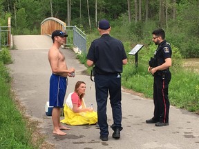 A police officer and a firefighter speak to  man and woman that were rescued by the marine unit of the LFD. (DEREK RUTTAN, The London Free Press)