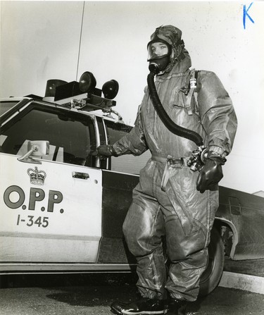 Petrolia OPP Constable Ken Hayward wears one of the force's protective suits they wear to deal with potential dangers in the Chemical Valley area, 1983. (London Free Press files)