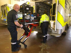 Middlesex-London paramedics Don Black and Samantha Quinlan pull out a stretcher from their ambulance. (Free Press file photo)