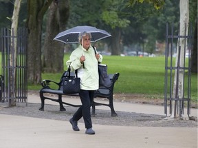 Lucretia Geleynse uses a polkadot umbrella to protect herself from the rain while walking through Victoria Park in London. (Free Press file photo)