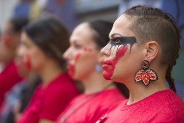 Wearing war paint, with a red hand across her mouth, signifying the lack of voice for the Indigenous women who are being trafficked across Canada, Vanessa Ambtman-Smith was at the silent protest in front of Atlohsa Family Healing Services on Richmond Street in London. (Mike Hensen/The London Free Press)