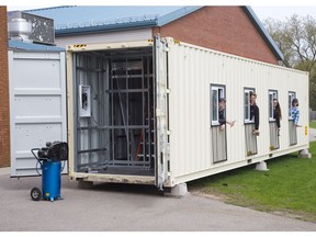 Caleb Kodde, left, Liam Dykstra, Julia Branderhorst and Cole Versnick are some of the Grade 12 students at London Christian High who are renovating a shipping container into a mobile computer classroom for children in Tanzania. (Derek Ruttan/The London Free Press)