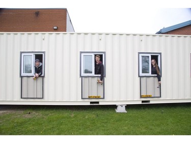 Caleb Kodde, left, Liam Dykstra, and Julia Branderhorst are three of the Grade 12 students at London Christian High who are renovating a shipping container into a mobile computer classroom for children in Tanzania. (Derek Ruttan/The London Free Press)