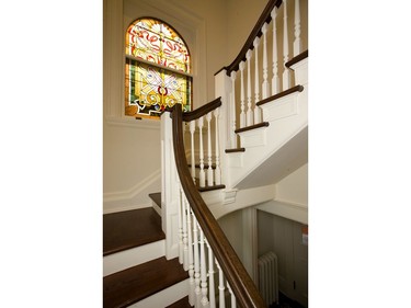 The front stairwell at 618 Wellington St. shows off a beautiful staircase leads past a large stained glass window.  (Mike Hensen/The London Free Press)