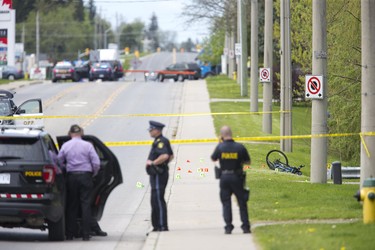 Police gather evidence at the scene of cyclist being struck by a vehicle on Broadway at Christie Street  in Tillsonburg, Ont. on Tuesday May 21, 2019. Derek Ruttan/The London Free Press/Postmedia Network