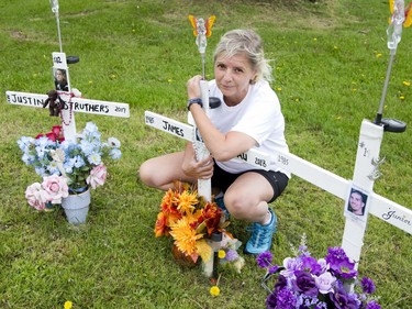 Lynn Pigeau embraces a cross bearing the name of her brother at a memorial for inmates that perished inside the Elgin Middlesex Detention Centre in London on Wednesday. James Pigeau is one of 14 prisoners who have died at the EMDC since 2009. (Derek Ruttan/The London Free Press)