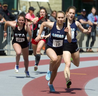 Chloe Knox of Lucas takes the handoff from Hailey Barnes to run the anchor leg during the senior girls' 4x100m relay during  Day 1 of the WOSSAA track and field meet Thursday May 23, 2019 at TD stadium in London.  Mike Hensen/The London Free Press